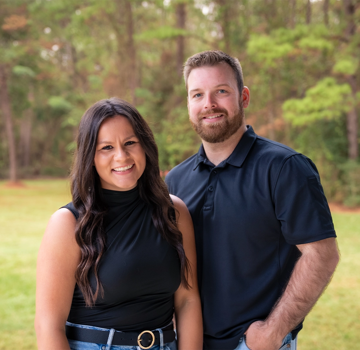 Portrait of the company founders standing outdoors together, smiling, representing the leadership team behind the brand.
