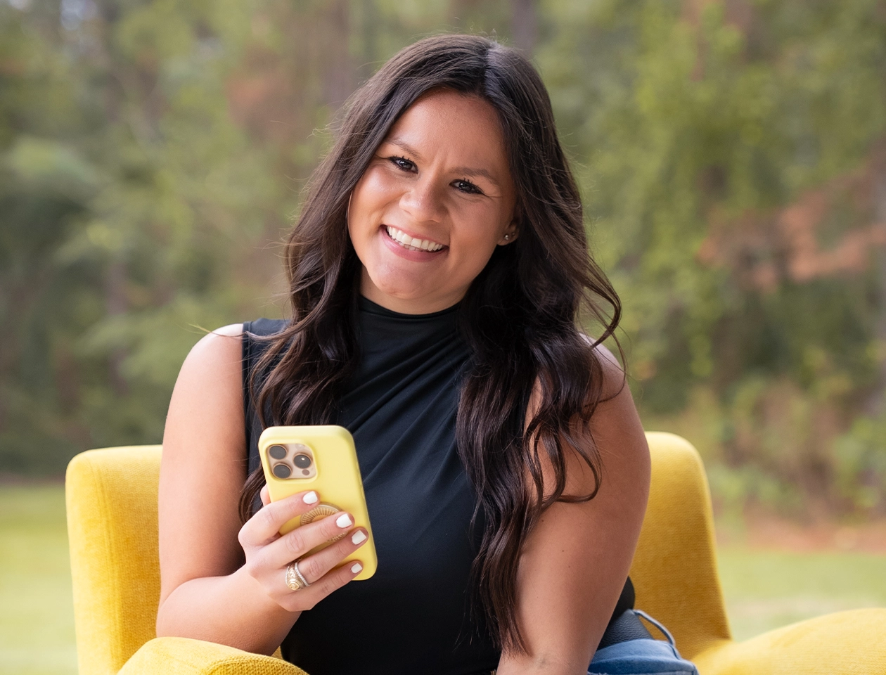 Founder of the company smiling outdoors with a smartphone, showcasing the leadership behind the digital marketing and creative agency.
