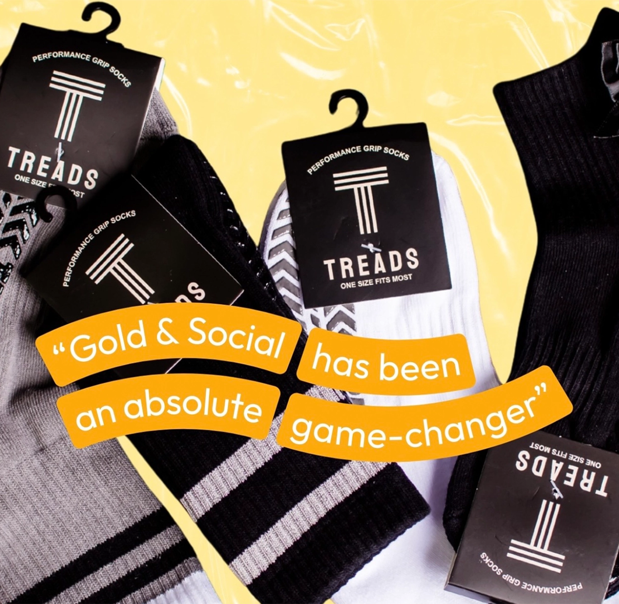 Flat lay of performance grip socks packaging labeled Treads with a testimonial quote reading “Gold & Social has been an absolute game-changer,” promoting athletic apparel and digital marketing success.